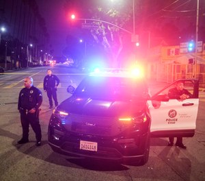 Police officers stand guard near a crime scene where three Los Angeles police officers were shot.