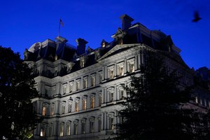 A bird flies over the Eisenhower Executive Office Building on the White House complex at dusk, June 1, 2021, in Washington. A fire at the Eisenhower Executive Office Building next to the White House led to the evacuation of workers as firefighters responded to the call.