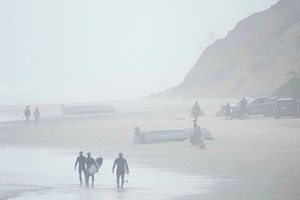 Two boats, one overturned, sit on Black's Beach on Sunday in San Diego. Authorities say multiple people were killed when two suspected smuggling boats overturned off the coast.