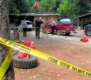 Investigators comb a property outside Wilderville, Ore., on Saturday, May 30, 2015.