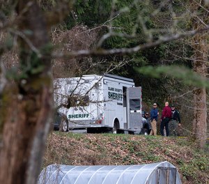 Law enforcement officials work at the scene along Wooding Road on Wednesday, March 22, 2023, east of Washougal, Wash.