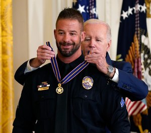 President Joe Biden presents the Medal of Valor, the nation's highest honor for bravery by a public safety officer, to Cpl. Jeffrey Farmer, of the Littletown, Colo., Police Dept.