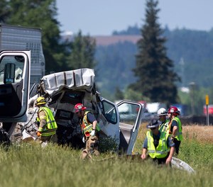 Oregon State Police troopers and firefighters work near the site of a wrecked tractor-trailer Thursday, May 18, 2023, along Interstate 5 in Albany, Ore.