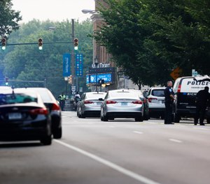Cars and police gather around Altria Theater, the site of a shooting at the Huguenot High School graduation, Tuesday, June 6, 2023, in Richmond, Va.