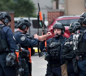 The St. Louis police SWAT team gathers in front of the city jail in downtown St. Louis, known as the City Justice Center, after a guard was reportedly taken hostage on Tuesday, Aug. 22, 2023.