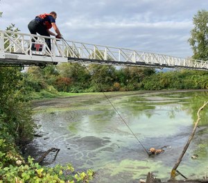 In this photo provided by Portland Fire and Rescue, a man charged with attempted murder who escaped from a psychiatric hospital while fully shackled is rescued from a muddy pond in Portland, Ore., Friday, Sept. 1, 2023.