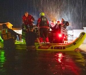 Firefighters use boats and a military truck to evacuate residents and pets as floodwaters rise in the Meadowbrook Acres neighborhood of Leominster, Mass.
