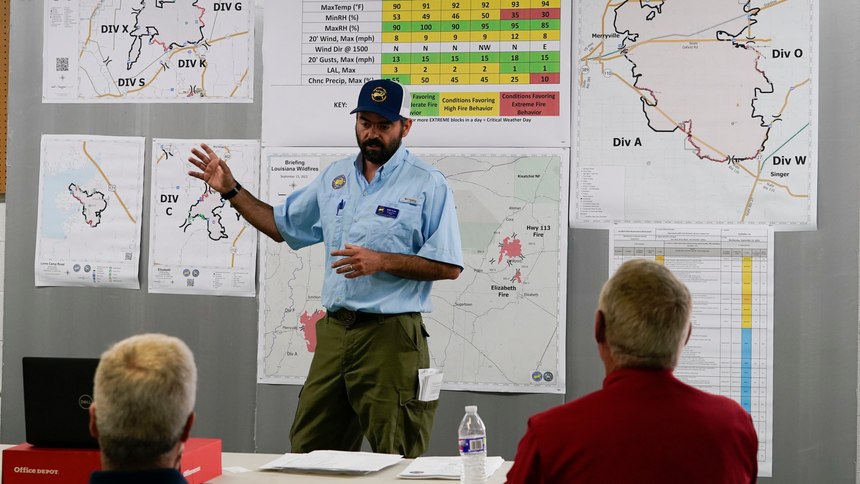 Kerry Clark, operations branch manager for the Southern area Blue Team of the National Incident Management System, conducts a morning briefing of the Louisiana wildfires in Leesville, La., Wednesday, Sept. 13, 2023.