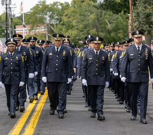 Members of the Hartford Police Department process down Marsh Street to the Wethersfield Village Cemetery for the burial of their fallen colleague, Detective Robert