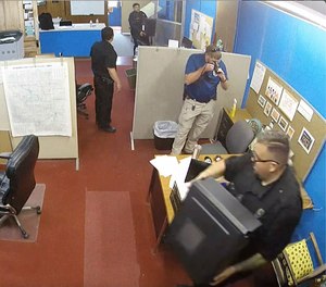 This image made from surveillance video provided by the Marion County Record shows members of the Marion, Kan., Police Department confiscating computers and cellphones from the publisher and staff of the Marion County Record, Aug. 11, 2023, in Marion, Kan.
