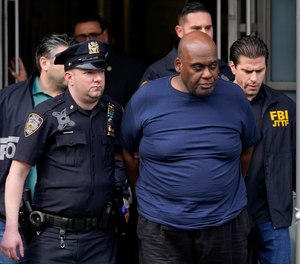New York City Police and law enforcement officials lead subway shooting suspect Frank R. James, 62, center, away from a police station, in New York, Wednesday, April 13, 2022.