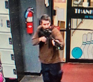 An unidentified gunman points a gun while entering Sparetime Recreation in Lewiston, Maine, on Wednesday, Oct. 25, 2023.