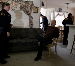San Bernardino County Probation Officer Marshawn Etchepare arrests parolee Kenneth Lucas for the second time in months after he was released just 60 days into a six-month sentence, during a night probation compliance sweep in Apple Valley, Calif.