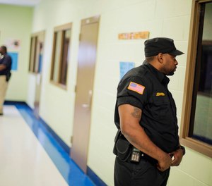 A Department of Juvenile Justice correctional officer stands guard outside a classroom at the Metro Regional Youth Detention Center, Wednesday, Aug. 20, 2014, in Atlanta.