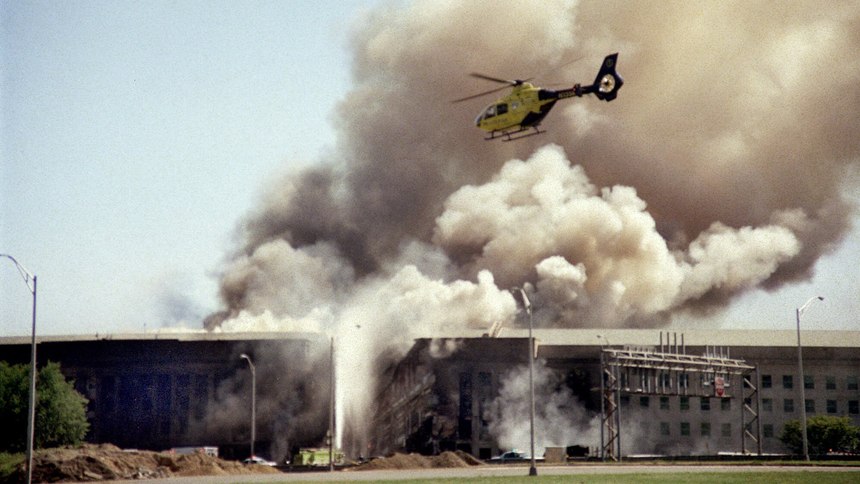 A helicopter flies over the Pentagon in Washington as smoke billows over the building immediately after the attack.