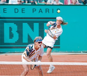 Murphy Jensen (left) waits at the net while his brother Luke volleys the ball during the final of the men's double match of the French Open tennis tournament in Paris, France, June 5, 1993. The brothers won the 1993 French Open.