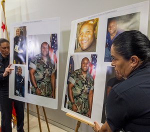 Los Angeles Police Public Information officers carry photos of suspect Christopher Dorner during a news conference at the LAPD headquarters in Los Angeles Thursday, Feb. 7, 2013.