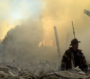 A lone firefighter moves through piles of debris at the site of the World Trade Center in New York, Tuesday, Sept. 11, 2001.