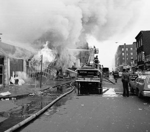 Firemen battle flames at a store in the Bronx borough of New York, one of many fires that broke out during the massive power failure that crippled the city for more than 24 hours, seen July 14, 1977. Firemen answered 1,500 alarms, 400 of which were actual fires. Forty of the fires were termed serious.