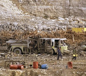 Investigators search through a highway construction site, Nov. 29, 1988 in Kansas City, Missouri where two early morning explosions shattered windows over a 10-mile area and killed six firefighters. The firefighters had been fighting a possible fire in a truck, officials said.