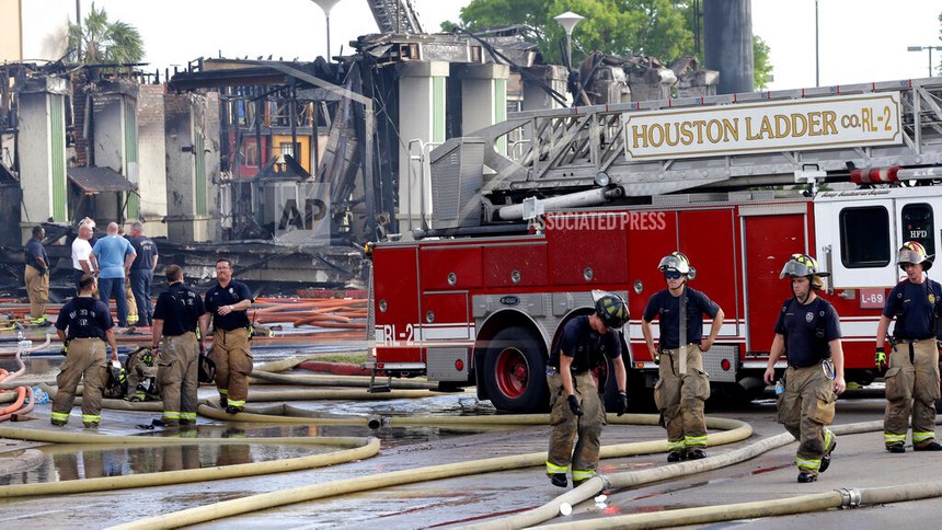 Houston firefighters clean up the scene where four firefighters were killed while battling a fire that engulfed a motel and restaurant on Friday, May 31, 2013. 