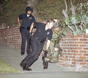 Two Los Angeles police officers and a National Guardsman position themselves to respond to semi-automatic gunfire in the Mid-Wilshire district of Los Angeles, Saturday, May 2, 1992. On Saturday marked the third day of unrest following the acquittal of four LAPD officers who were accused of beating Rodney King.