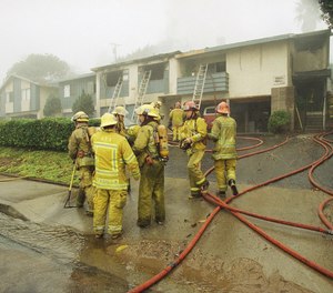 Firefighters from Anaheim and Fullerton help extinguish a fire in an apartment building in Fullerton, Calif., which resulted when a small plane crashed into it early in morning on Monday, Nov. 20, 1995.