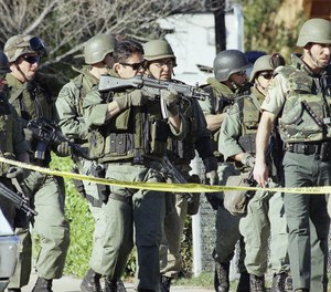 Los Angeles County Sheriff Department SWAT team personnel begin a house-to-hour search for robbery suspects, Friday, Feb. 28, 1997 in the North Hollywood section of Los Angeles.