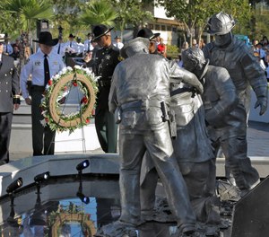 Dignitaries place a wreath at a 9/11 Fallen Heroes Memorial after it was unveiled outside the Hillsborough County Sheriff's Office Thursday, Sept. 11, 2014, in Tampa, Fla. The memorial includes a beam from the World Trade Center Tower 2.