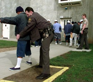 Correctional officer A. Andrews searches an inmate at California State Prison, Sacramento, in Folsom, Calif., Thursday, March 10, 1999.