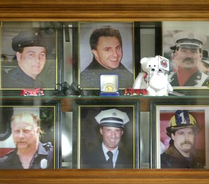 In this 2001 file photo, a display case in the lobby of the Worcester Fire Department Grove Street station memorializes six firefighters who were killed at the cold storage warehouse fire Dec. 3, 1999, in Worcester, Mass. Pictured from top left clockwise are firefighters Joseph McGuirk, James Lyons III, Jeremiah Lucey, Paul Brotherton, Lt. Thomas Spencer and Timothy Jackson.
