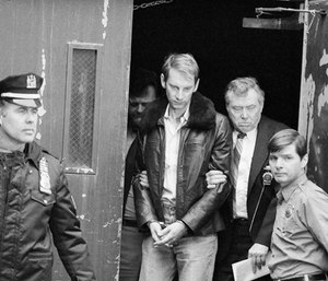 Bernhard Goetz, escorted by detectives, leaves New York Police headquarters, Jan. 3, 1984, after his return from Concord, N.H., where he turned himself in and admitted to shooting four youths on a New York subway train in December. (AP Photo)