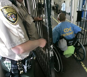 In this April 9, 2008 file photo, a wheelchair-bound inmate wheels himself through a check point at the California Medical Facility, in Vacaville, Calif. (AP Photo/Rich Pedroncelli, file)