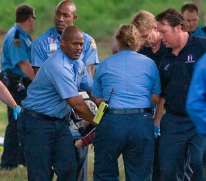 Emergency personnel carry a two-year-old boy to a waiting ambulance after he fell into White Oak Bayou in Houston on Thursday, Feb. 26, 2009.