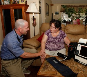 In this Aug. 31, 2011 photo, Eagle County paramedic Kevin Creek checks the pulse of Danielle Hefferan, 21, during a house call at her home in Eagle, Colo. (AP Photo/Ed Andrieski)