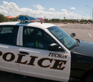 A police car blocks an entrance to Davis-Monthan Air Force Base in Tucson, Ariz., Friday, Sept. 16, 2011. (AP Photo/Gary M. Williams)