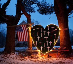 In this Dec. 14, 2013 file photo, a makeshift memorial with crosses for the victims of the Sandy Hook Elementary School shooting massacre stands outside a home in Newtown, Conn., on the one-year anniversary of the shootings.