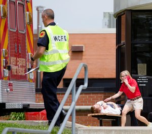 Volunteers participating in a training exercise for an active shooter simulate exiting the main entrance of Hopewell Elementary School with injuries Wednesday, May 25, 2016, in West Chester, Ohio.