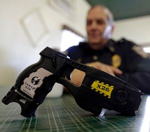 In this Nov. 14, 2013, file photo, a Taser X26 sits on a table in Knightstown, Ind.