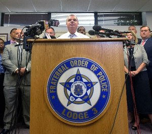 Gene Ryan, center, president of the Baltimore Fraternal Order of Police, speaks during a news conference in Baltimore, Wednesday, July 27, 2016.