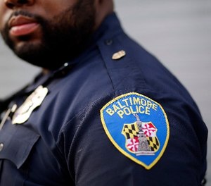 In this March 31, 2016, file photo, Baltimore Police Department Officer Jordan Distance stands on a street corner during a foot patrol in Baltimore. (AP Photo/Patrick Semansky, File)