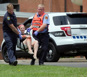 In a May 25, 2016 file photo, a volunteer with simulated injuries is carried during a training exercise for an active shooter at Hopewell Elementary School, in West Chester, Ohio.