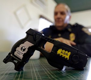 In this Nov. 14, 2013, file photo, a Taser X26 sits on a table in Knightstown, Ind.