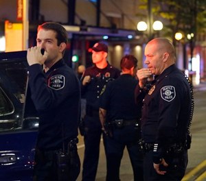 Police officers wait near a car near the scene of a shooting Wednesday, Nov. 9, 2016, in downtown Seattle.