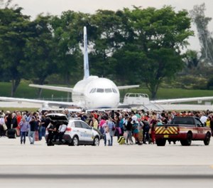 People stand on the tarmac at the Fort Lauderdale-Hollywood International Airport after a shooter opened fire inside a terminal of the airport, killing several people and wounding others before being taken into custody, Friday, Jan. 6, 2017, in Fort Lauderdale, Fla.