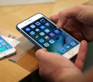 In this Friday, Sept. 16, 2016, file photo, a customer sets up his new iPhone 7 Plus in Chicago.