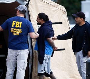 A man is taken into custody by FBI agents Wednesday, May 17, 2017, in Los Angeles. (AP Photo/Jae C. Hong)