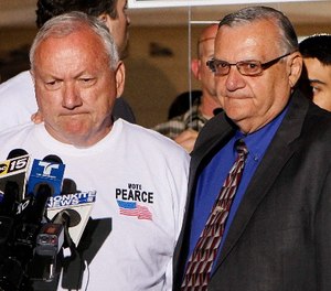 In this Nov. 8, 2011 file photo, Arizona State Sen. Russell Pearce, R-Mesa, left, prepares to address the media in Mesa, Ariz., after losing his recall election bid, as Maricopa County Sheriff Joe Arpiao, right, stands by his side. (AP Photo/Matt York, File)