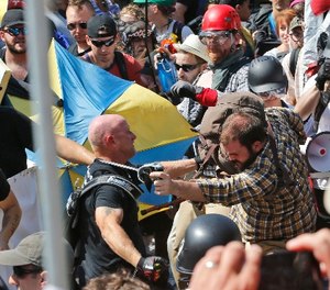 White nationalist demonstrators clash with counter demonstrators at the entrance to Lee Park in Charlottesville, Va., Saturday, Aug. 12, 2017.