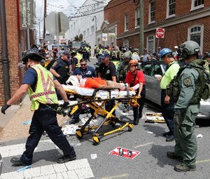Rescue personnel help injured people after a car ran into a large group of protesters after an white nationalist rally in Charlottesville, Va., Saturday, Aug. 12, 2017.